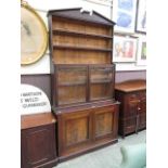 An early 20th century walnut bookcase, the pediment over open storage, glazed doors, and two blind