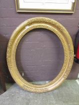 An ornate oval gilt frameMeasurements: - Front aperture; H: 73cm W: 61cm- Recess of frame; H: 77cm
