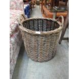 A wicker twin handled log basket