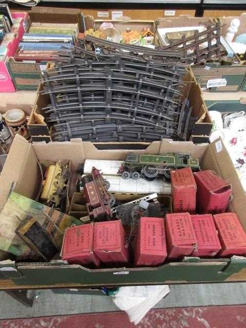 Two trays containing 0 gauge railway track, engines, wagons etc.