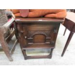 A mid-20th century oak hall cupboard with carved panel and door