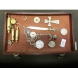 A tray containing brass whistles, rings, watches, etc