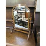 An early 20th century oak framed swing toilet mirror