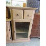 A modern cabinet, two drawers over single glazed door