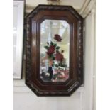 A carved oak bevel glass mirror with painted rose design