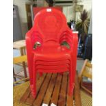 A set of four red PVC stacking children's chairs with lion design to back