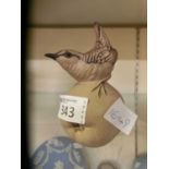 A Poole Pottery model of a bird sat on a fruit