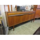 A mid-20th century teak sideboard with three drawers over three cupboard doors, possibly Macintosh