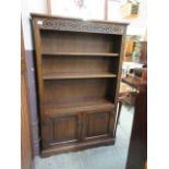 A high quality oak bookcase having linen fold doors to base