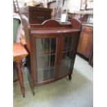 An early 20th century oak bow fronted glazed bookcase