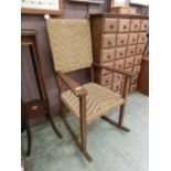 An early 20th century beech framed rocking chair with woven back and seat`