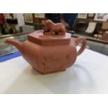 An oriental clay teapot with foodog to lidCrack to top of teapot near lid. Two chips to lid. No
