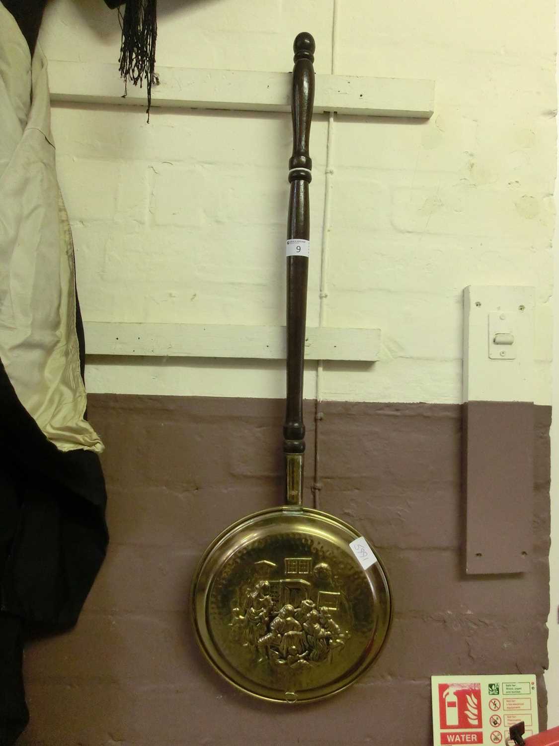 An embossed brass bed warming pan