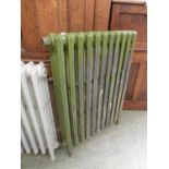 A cast iron radiator painted green and grey