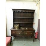 An early 20th century oak dresser, the plate rack over two drawers, shaped apron, and cabriole legs