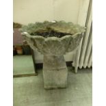 A composite stone garden pot on plinth