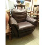 A brown leather upholstered reclining and revolving armchair