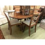 A reproduction mahogany drop-leaf dining table along with a set of four matching chairs