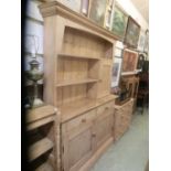 A 19th century pine dresser, the rack with open shelving and cupboard over the base with two drawers