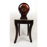 A Victorian mahogany hall chair, the circular turned back over the dish seat on reeded sabre legs,