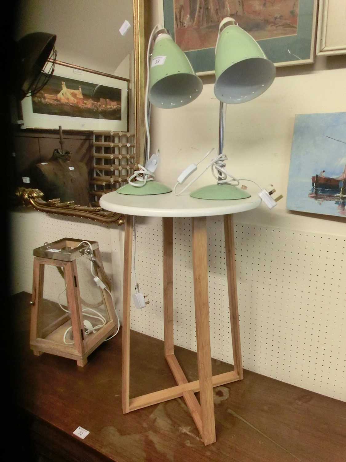 A pair of green desk lamps along with an occasional table