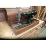 A Singer manual sewing machine in dome case