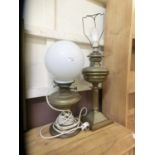 A brass oil lamp along with an early 20th century converted oil lamp