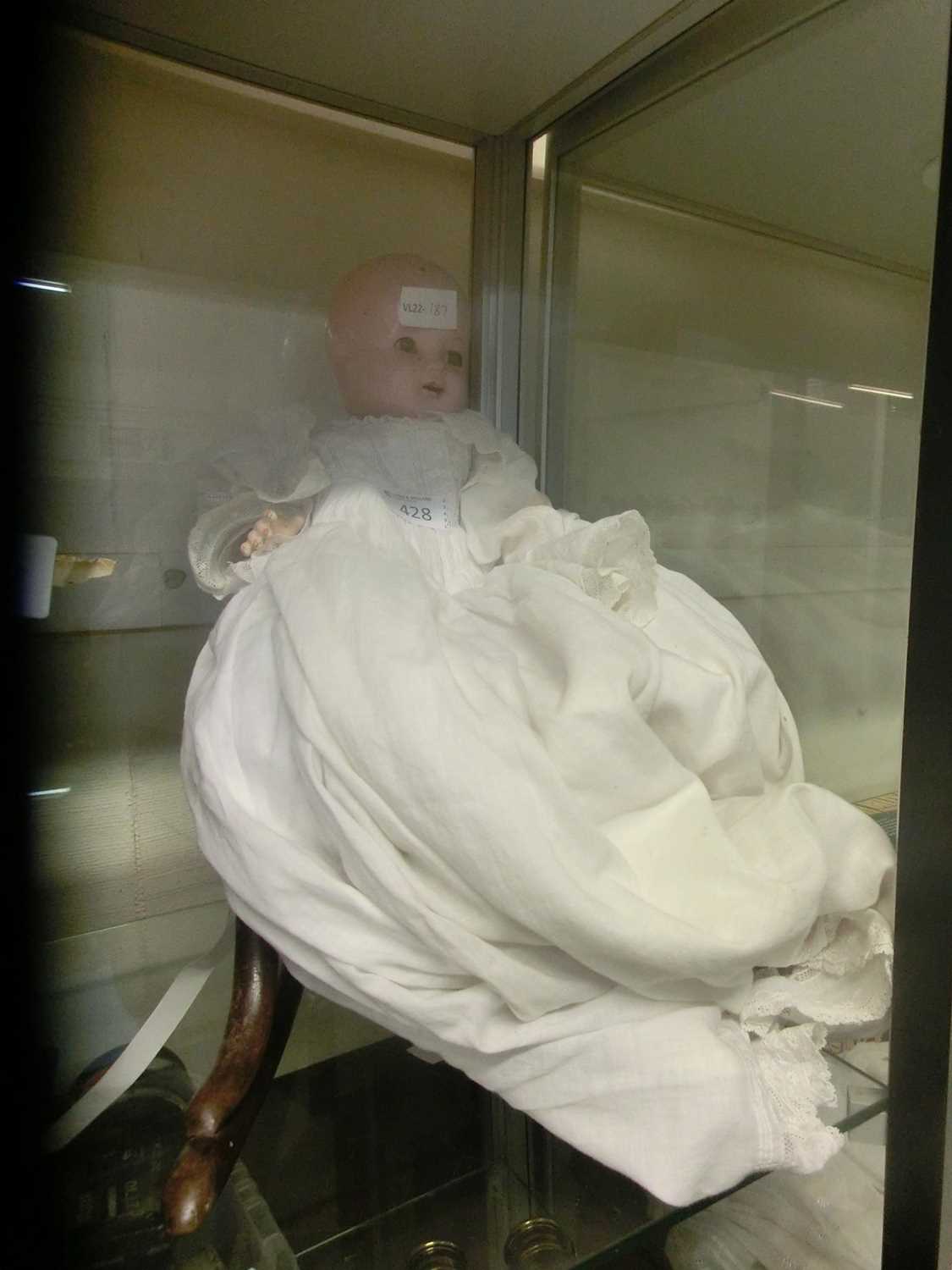 A doll marked 'Nancy' to neck on bentwood rocking chair