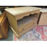 A waxed pine cabinet having open storage above single drawer