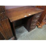 An early 20th century oak desk having single pedestal on four drawers and slide