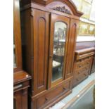 A late Victorian mahogany wardrobe having a centre bevel glass mirrored door with drawer to base