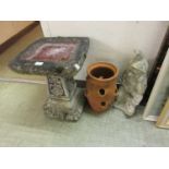 A weathered stoneware bird bath together with a weathered stoneware gnome and a clay strawberry pot