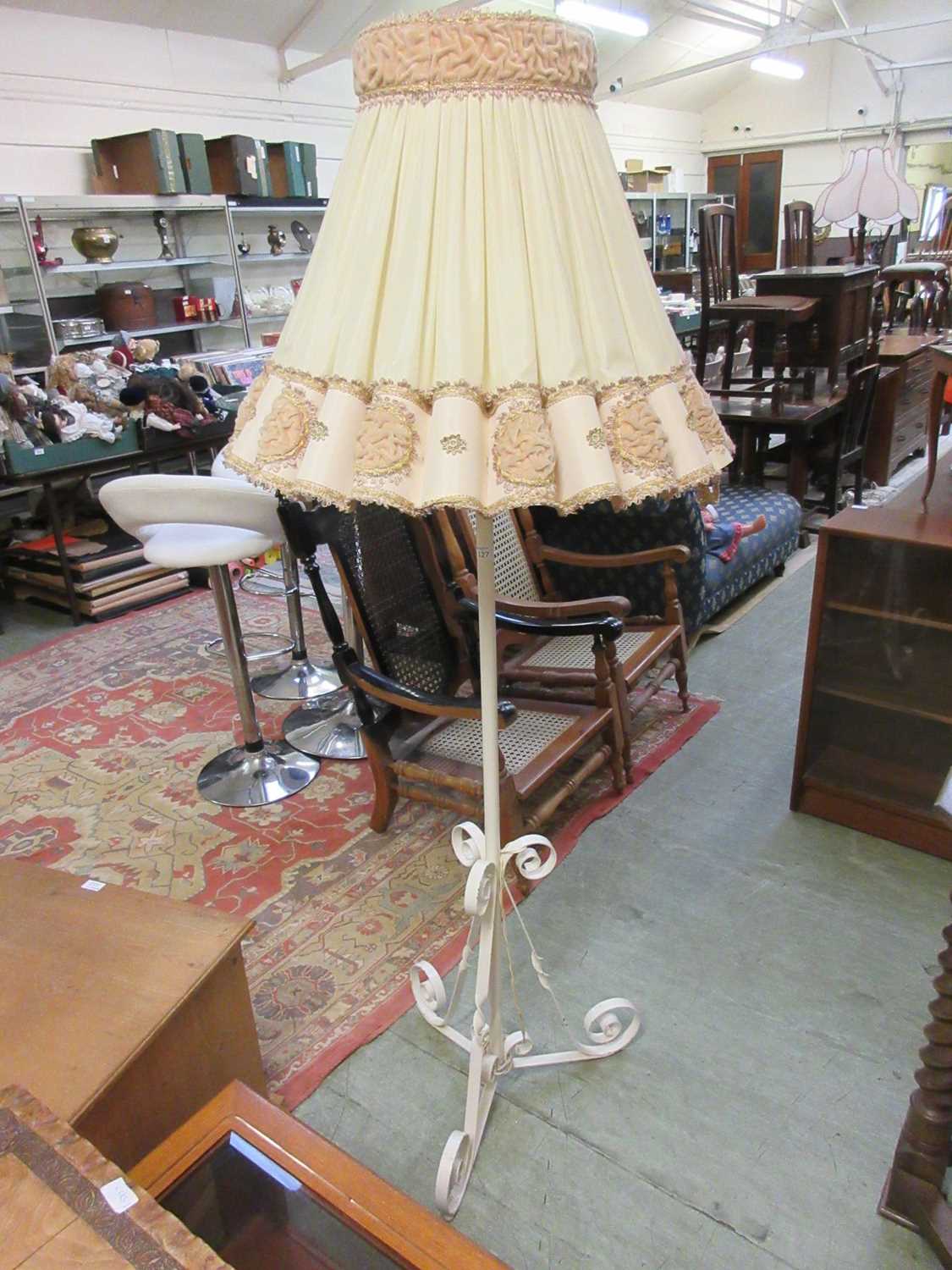 A cream painted metal standard lamp with shade