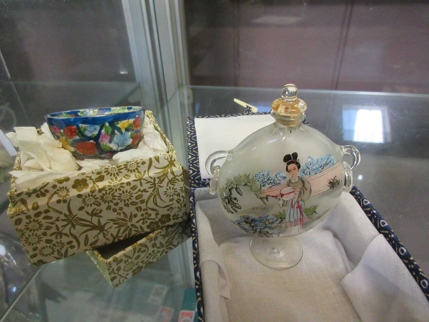 A glass oriental perfume bottle together with an oriental miniature bowl