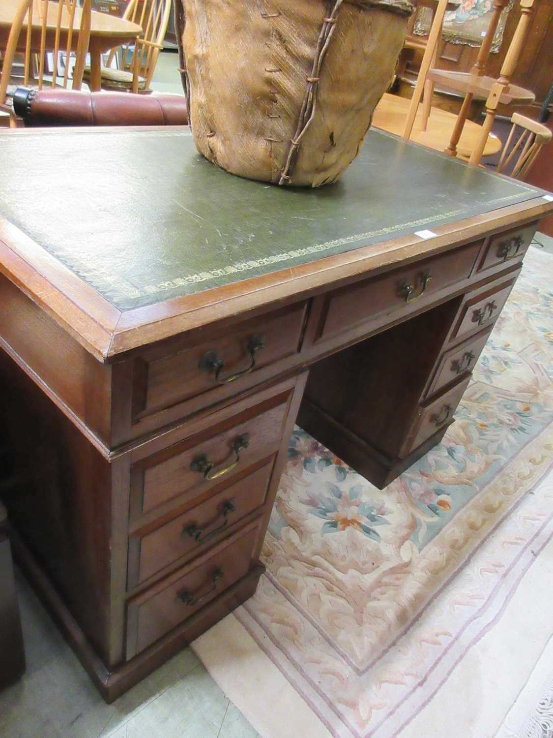 An Edwardian walnut twin pedestal desk having a long drawer to top, the pedestal having three