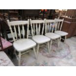 A set of four cream painted spindle back chairs
