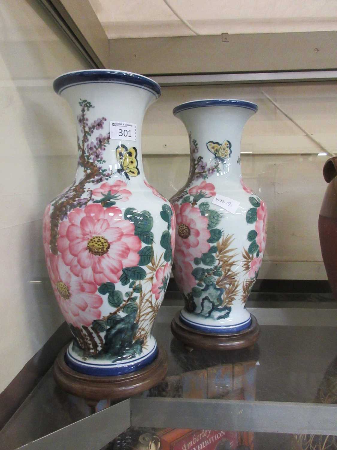 A pair of oriental inspired vases with floral and butterfly design