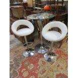A modern chrome and circular glass topped bistro table together with a pair of chrome and cream