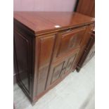 A Chinese hardwood drinks cabinet having pull-down flap above two cupboard doors