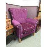 A purple upholstered button back wing armchair