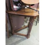 A mid-20th century oak corner table with barley twist supports