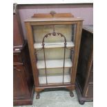 An early 20th century walnut single door display cabinet on cabriole legs