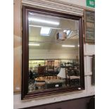 A modern cherrywood framed bevel glass mirror