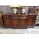 A reproduction mahogany break front sideboard