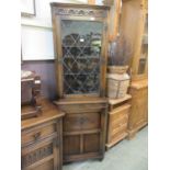 A reproduction oak floor standing corner cupboard with leaded glazed door to top