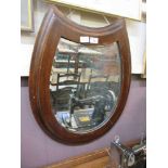 An early 20th century oak framed bevel glass mirror in the form of a horseshoeRepaired split to