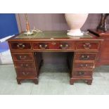 A reproduction mahogany twin pedestal desk with a tooled green leather insert to top