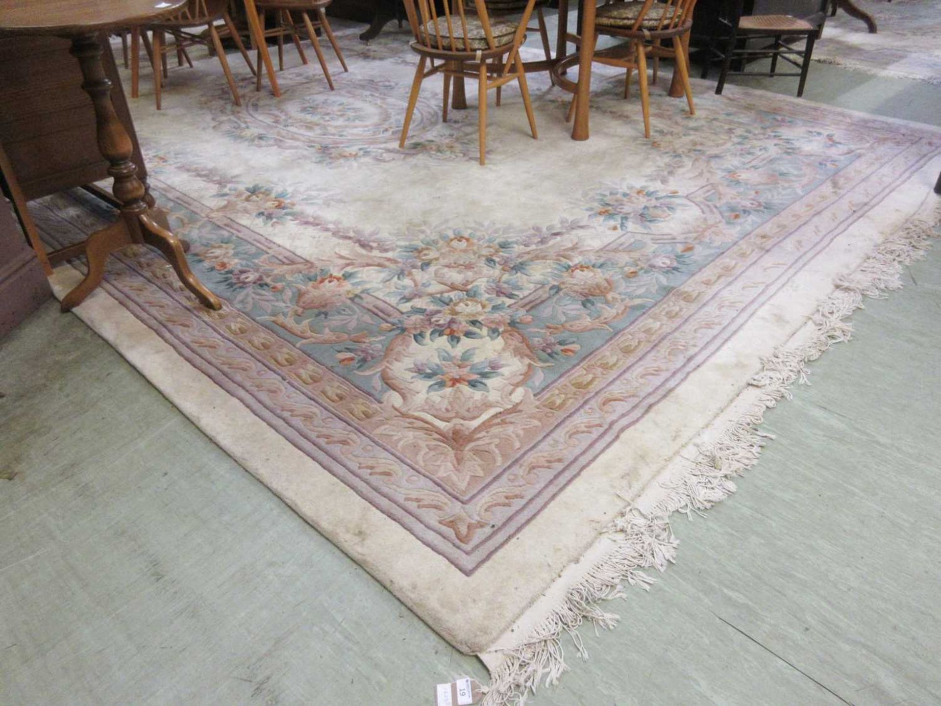 A large rectangular cream Chinese rug measuring 490cm by 322cm