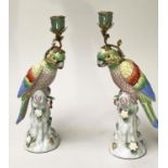 PARROT CANDLESTICKS, a pair, Continental style porcelain in the form of perched parrots, 36cm H. (2)
