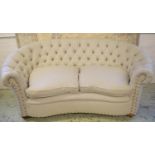 SOFA, 82cm H x 180cm W, kidney shaped in ticking with seat cushions and castors.